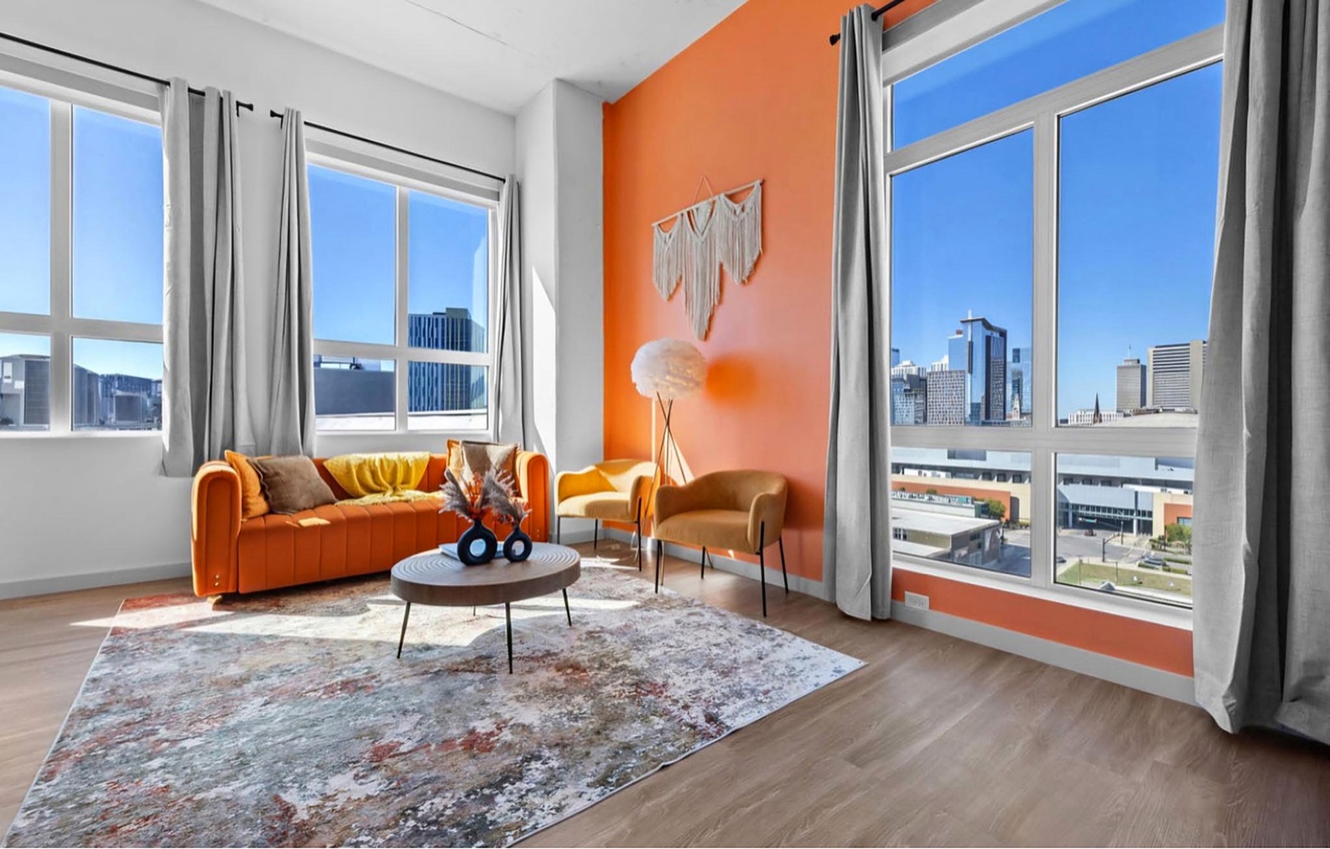 Finished living room with a vivid orange feature wall and crisp white trim